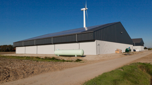 Landbouwschuur met zonnepanelen en windturbine