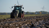 Tractor ploegt het veld om de grond klaar te maken voor het zaaien