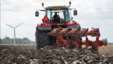 Tractor ploegt het veld om de grond klaar te maken voor het zaaien