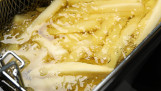 Verse aardappelfrites worden goudbruin gefrituurd in hete olie