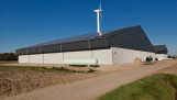 Landbouwschuur met zonnepanelen en windturbine
