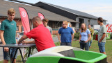 Bezoekers in gesprek tijdens een agrarisch evenement op een boerenerf.