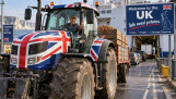 Britse boer rijdt met een met de Union Jack versierde tractor vol aardappelen een veerboot op naar het Verenigd Koninkrijk.